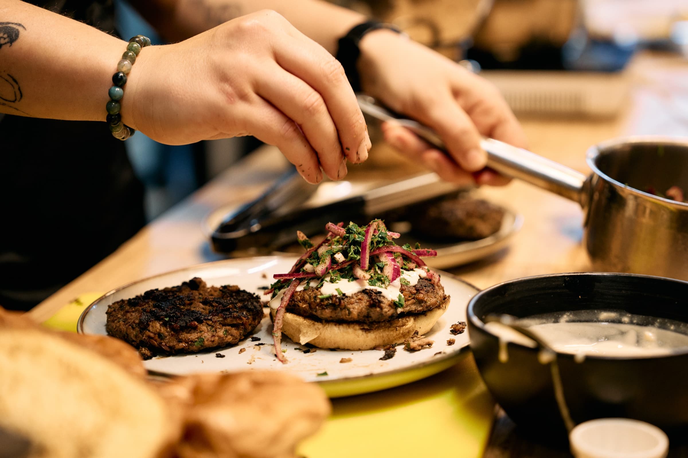 A Baytna chef plating freshly made Syrian kofta burgers