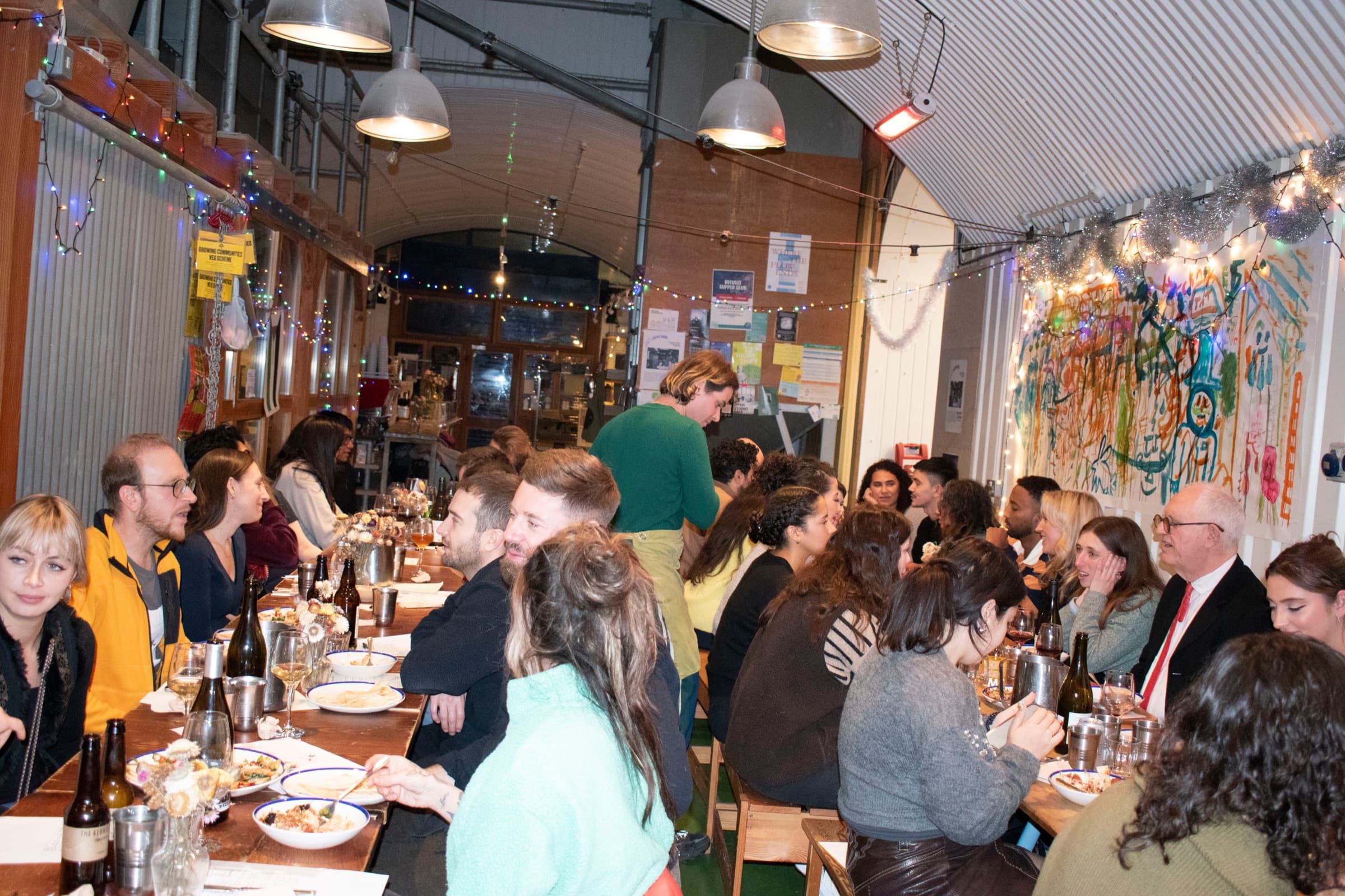 A Baytna supper club: guests sharing dinner at a long candle-lit table